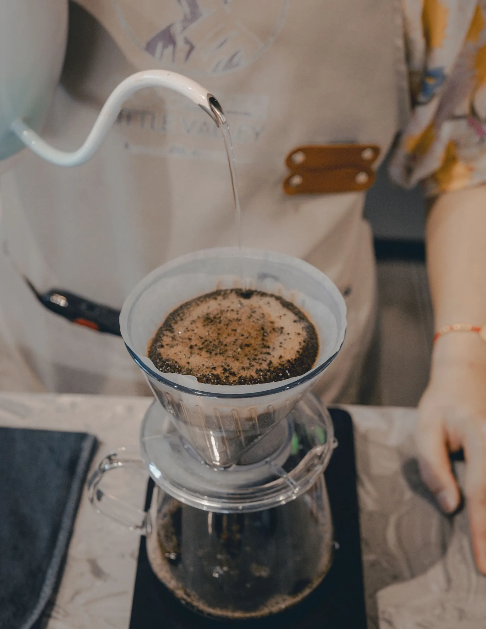 Barista brewing a pour-over coffee at the bar